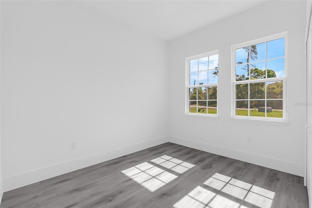 3428 Southwest 165th Loop Ocala, FL 34473 - Photo 20 of 43 an empty room with wooden floor and windows