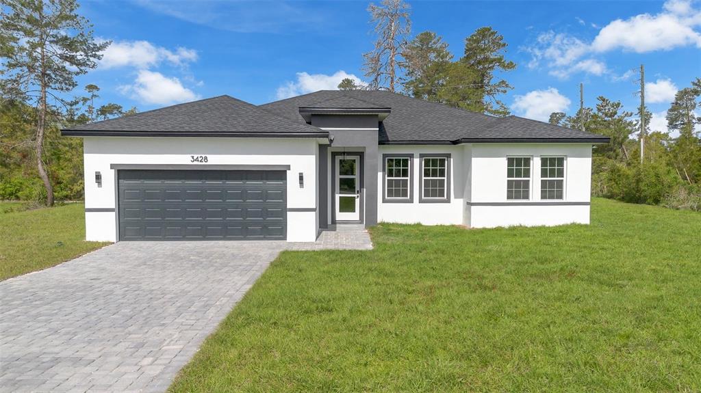 3428 Southwest 165th Loop Ocala, FL 34473 - Photo 2 of 43 a front view of a house with a garden