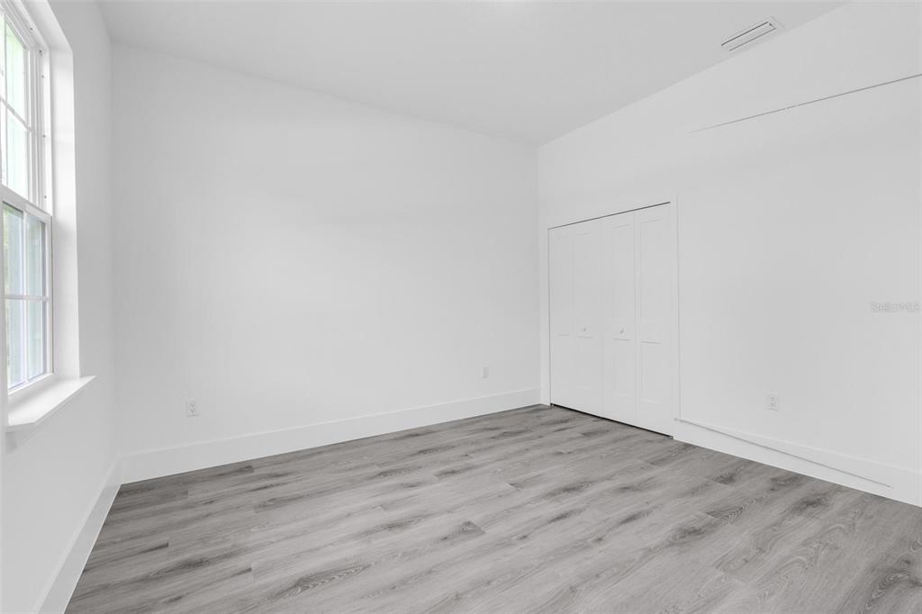 3428 Southwest 165th Loop Ocala, FL 34473 - Photo 21 of 43 an empty room with wooden floor and windows