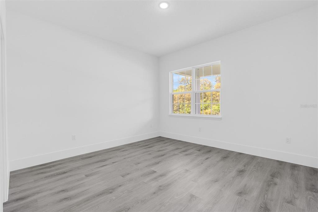 3428 Southwest 165th Loop Ocala, FL 34473 - Photo 22 of 43 an empty room with wooden floor and a window