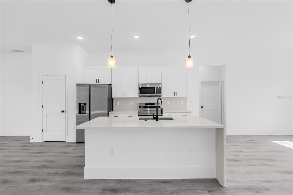 3428 Southwest 165th Loop Ocala, FL 34473 - Photo 9 of 43 a kitchen with kitchen island a white counter top space stainless steel appliances and wooden floor