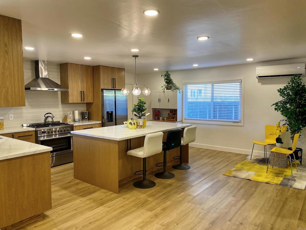 12401 Metate Lane Poway, CA 92064 - Photo 9 of 42 a kitchen with stainless steel appliances granite countertop a sink a stove and a wooden floors