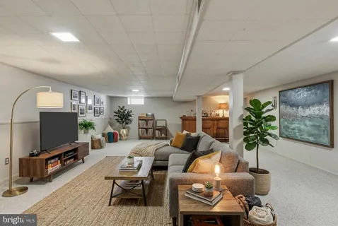a living room with furniture a chandelier and a flat screen tv