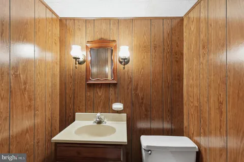 a bathroom with a sink a toilet and mirror
