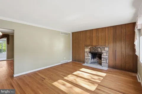 a view of empty room with wooden floor and fireplace