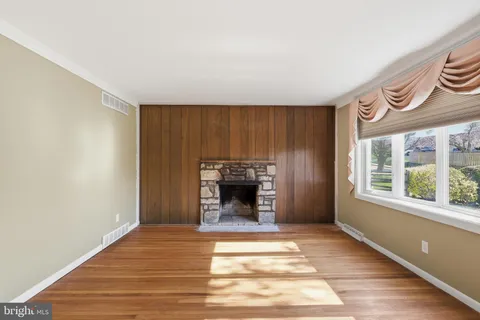 a view of an empty room with a window and fireplace