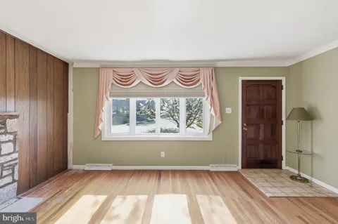 an empty room with wooden floor and a window