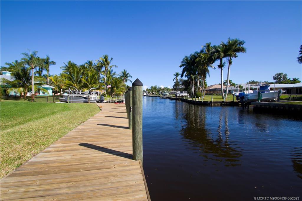 a view of a lake with boats and palm trees