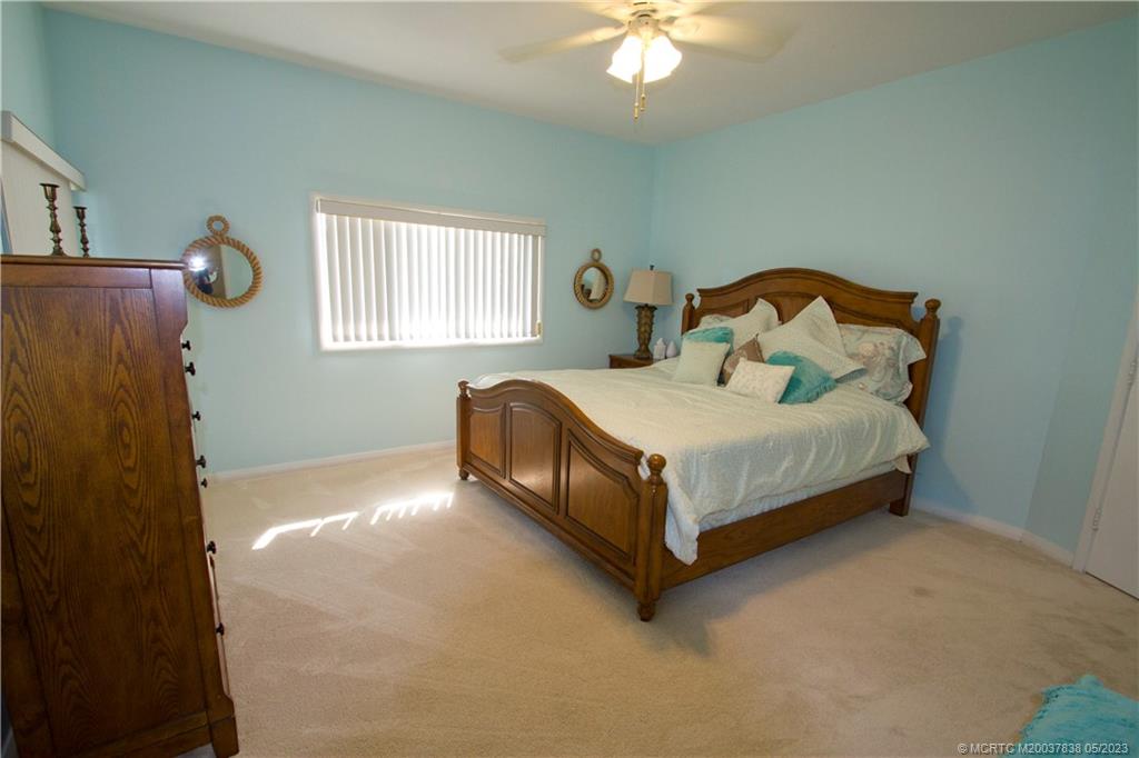 1790 Northwest River Trail Stuart, FL 34994 - Photo 24 of 44 a bedroom with a bed and a chandelier