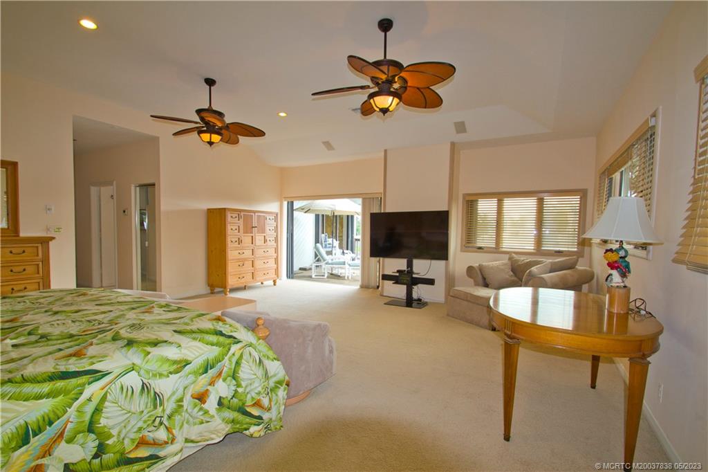 1790 Northwest River Trail Stuart, FL 34994 - Photo 30 of 44 a spacious bedroom with a bed and a chandelier