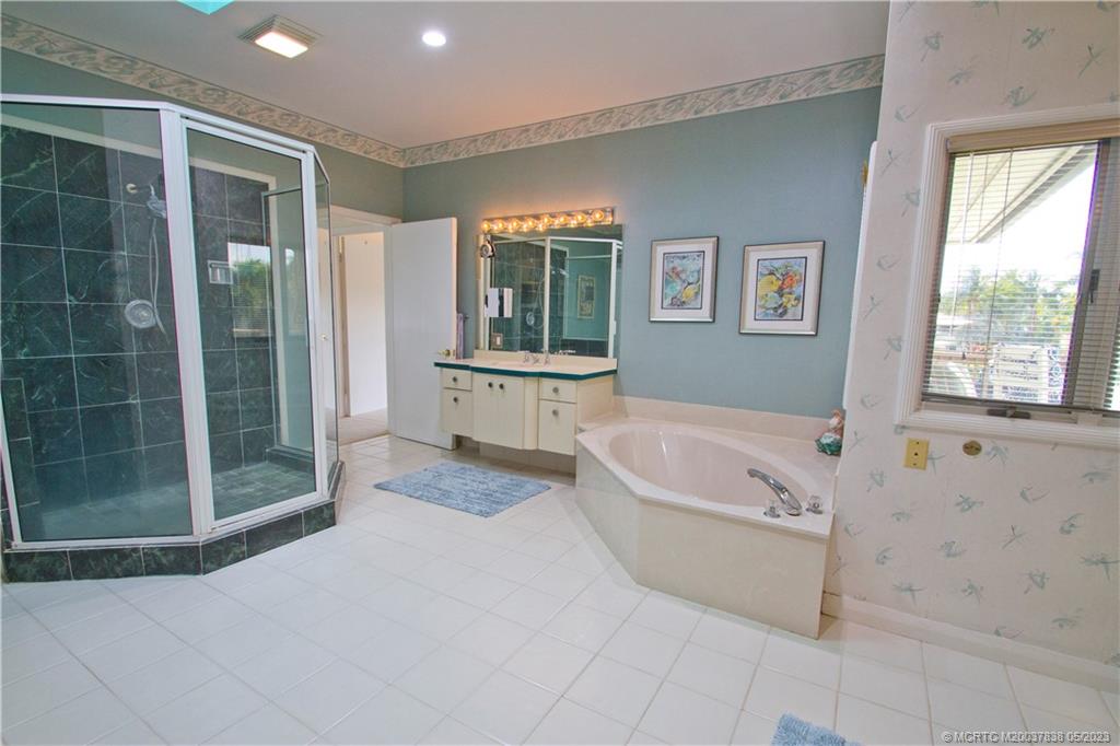 1790 Northwest River Trail Stuart, FL 34994 - Photo 35 of 44 a spacious bathroom with a bathtub and a shower