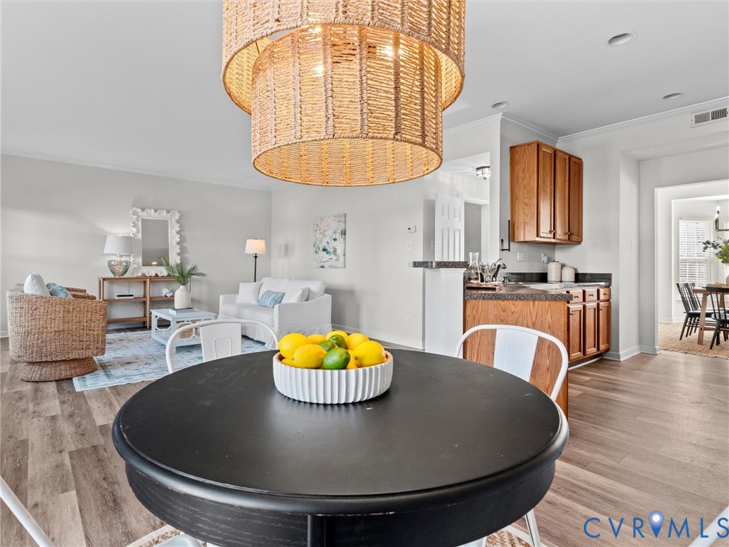 9524 Spring Moss Terrace, Unit 9524 Glen Allen, VA 23060 - Photo 15 of 41 a kitchen with stainless steel appliances granite countertop a stove a kitchen island a dining table and a chandelier