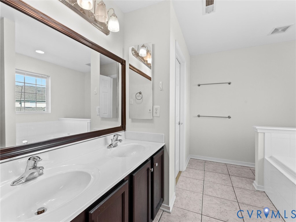 9524 Spring Moss Terrace, Unit 9524 Glen Allen, VA 23060 - Photo 25 of 41 a spacious bathroom with a sink a mirror and a shower