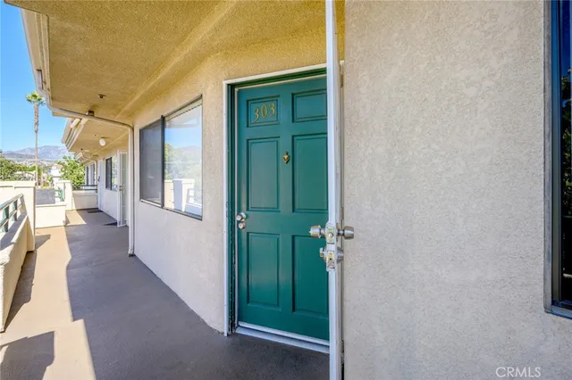 a view of a hallway with wooden floor and a livingroom with furniture