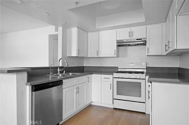 a kitchen with white cabinets and white appliances