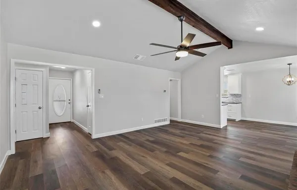 a view of empty room with wooden floor and ceiling fan