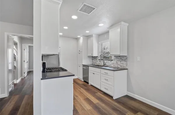 a kitchen with granite countertop white cabinets and white appliances