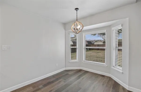 a view of wooden floor chandelier and window in a room