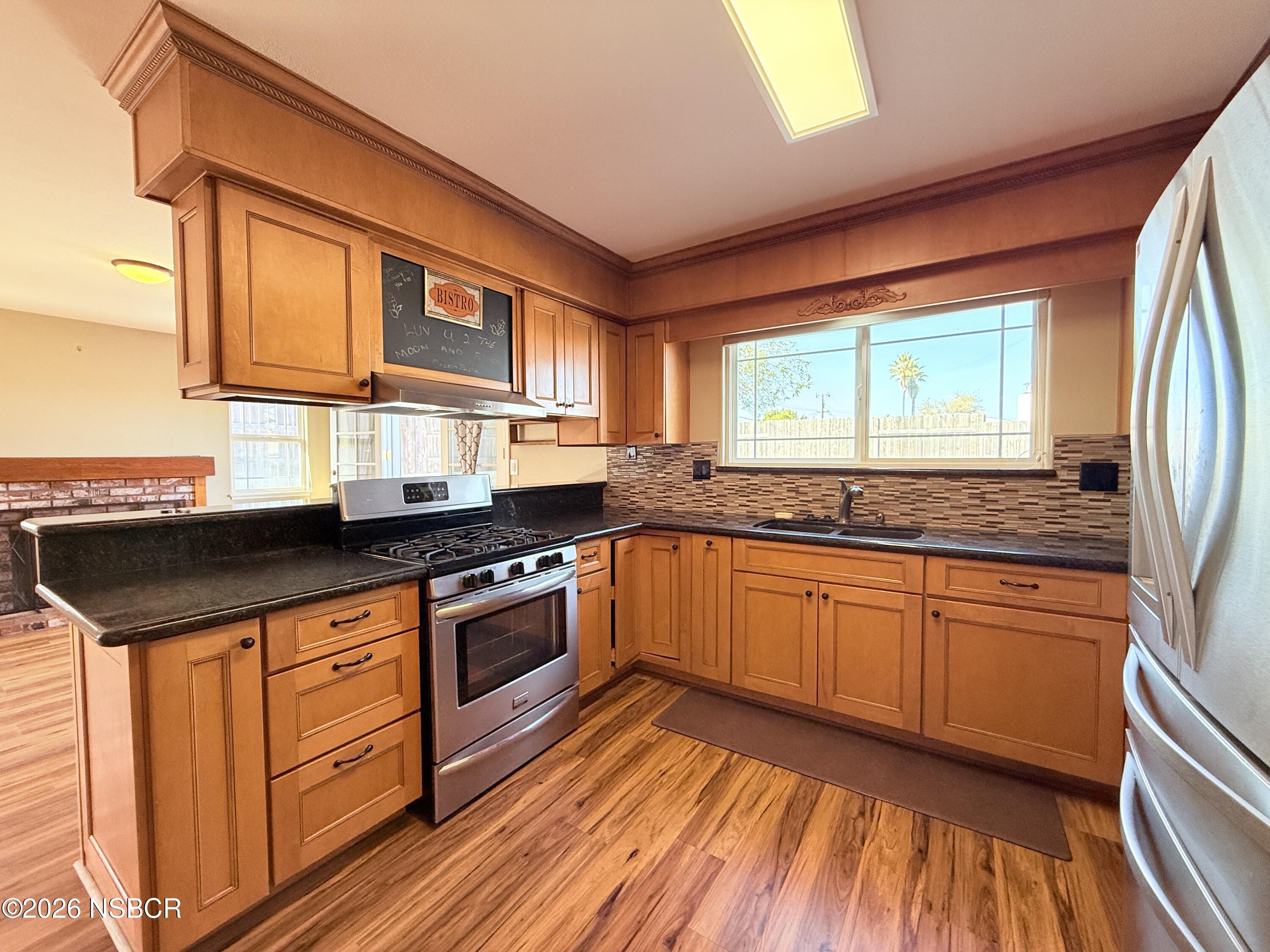 4031 Hillview Road Santa Maria, CA 93455 - Photo 3 of 16 a kitchen with stainless steel appliances granite countertop wooden floor sink stove and granite counter top