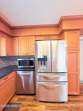 a view of a kitchen with a sink and a refrigerator