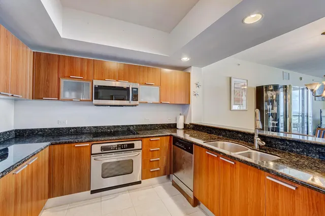 a kitchen with stainless steel appliances granite countertop a sink a stove and a granite counter top