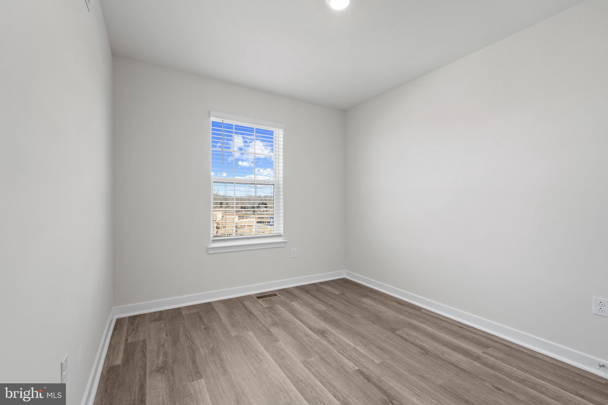 7512 Fern Gully Way Brandywine, MD 20613 - Photo 19 of 26 a view of an empty room with wooden floor and a window