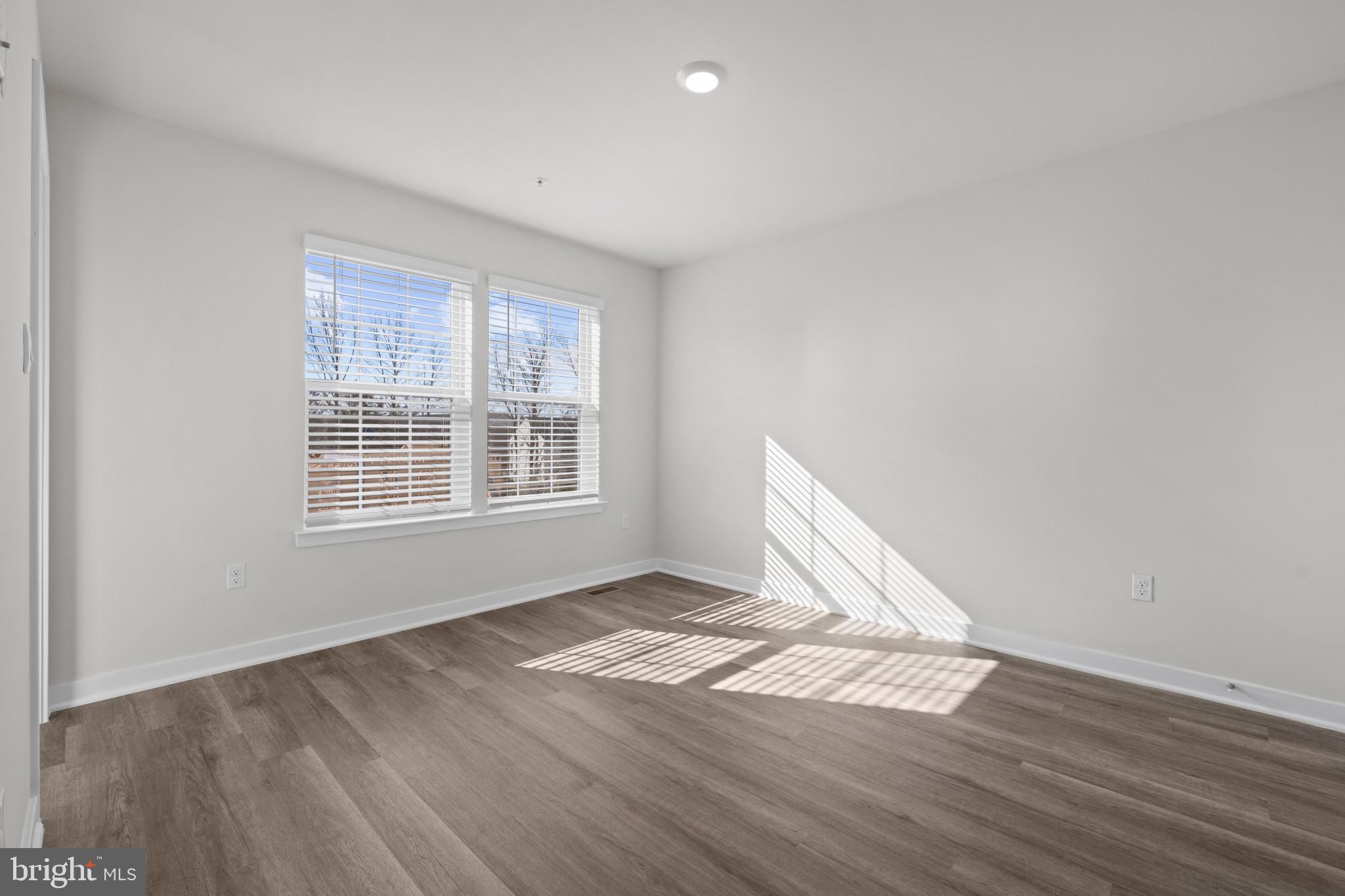 7512 Fern Gully Way Brandywine, MD 20613 - Photo 21 of 26 a view of an empty room with wooden floor and a window
