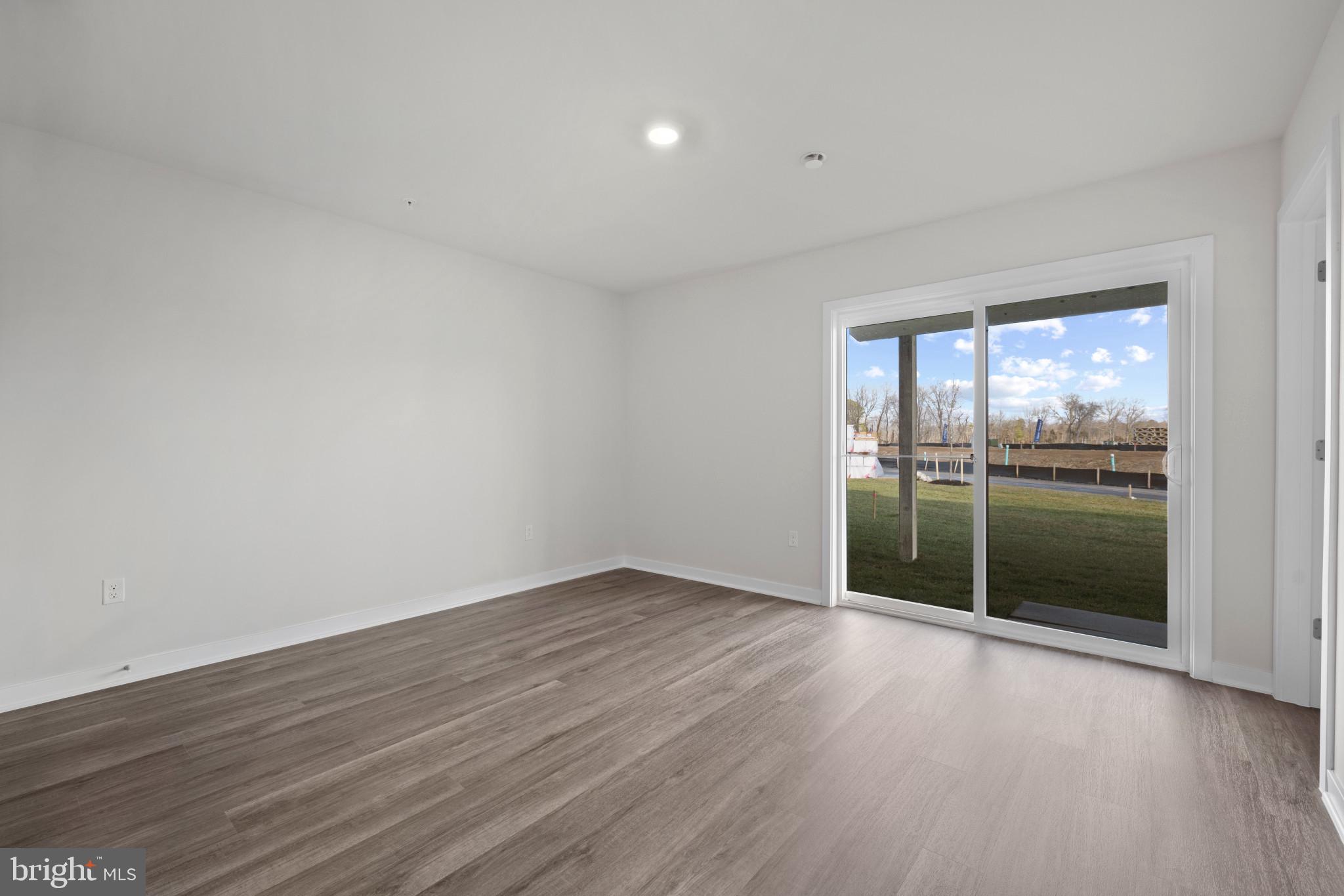7512 Fern Gully Way Brandywine, MD 20613 - Photo 5 of 26 a view of an empty room with wooden floor and a window