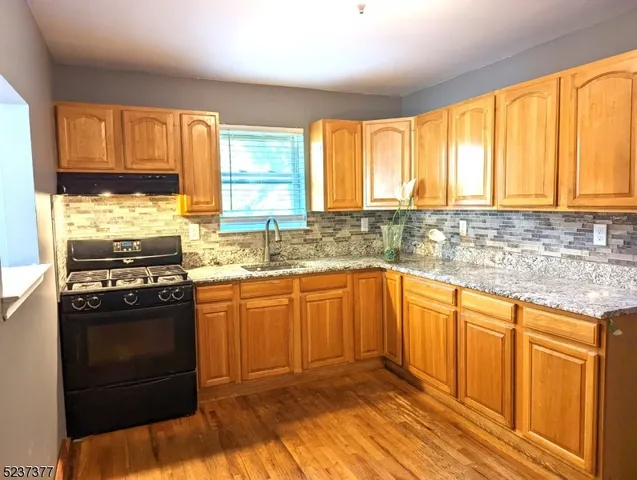 a kitchen with stainless steel appliances granite countertop a stove a sink and a microwave