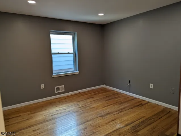 a view of a room with wooden floor and window