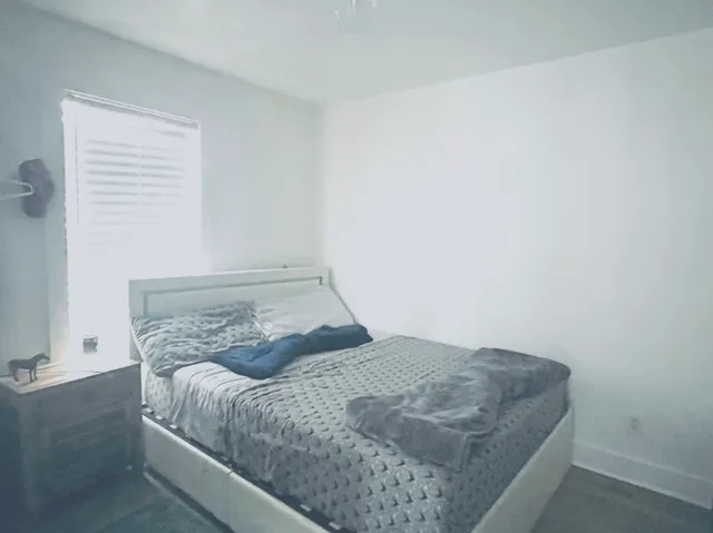 a bedroom with a bed and a window