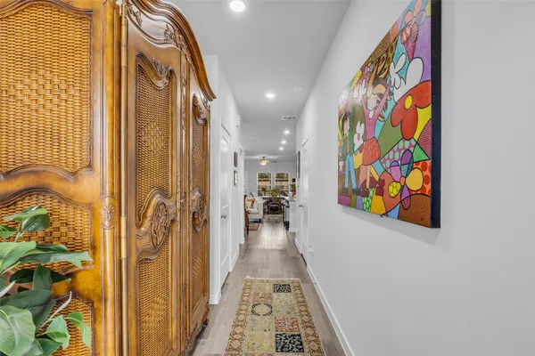 a view of a hallway with furniture and paintings on the wall