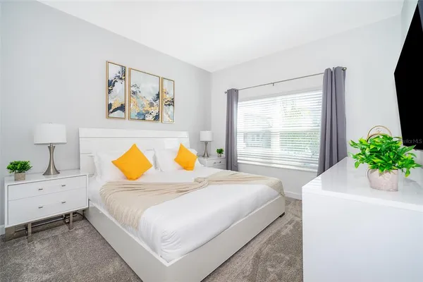 a bed sitting in a bedroom next to a window