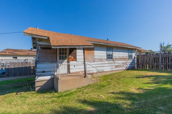a backyard of a house with table and chairs