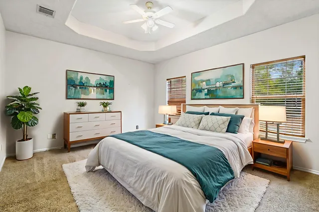 a bedroom with a bed a couch and potted plant