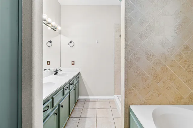 a bathroom with a tub sink and mirror