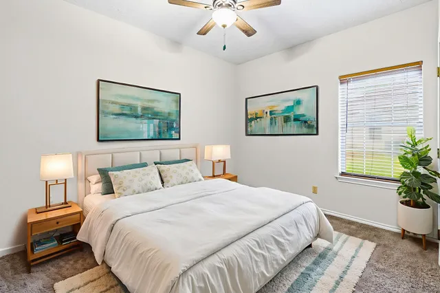 a bedroom with a bed and a painting on the wall