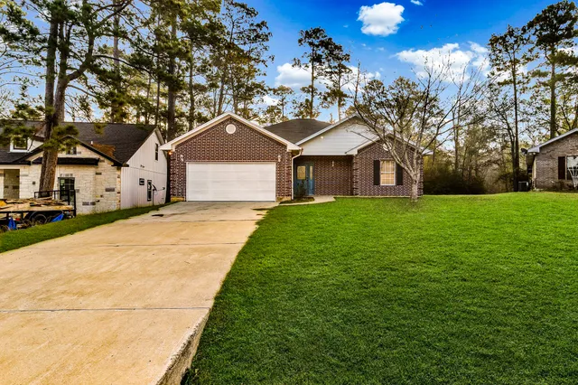 a front view of a house with a yard and trees