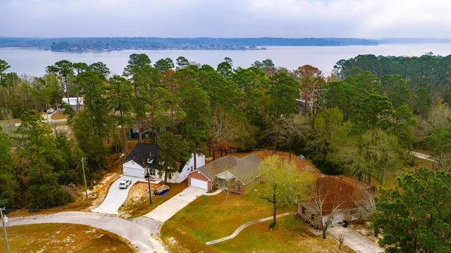 an aerial view of a house with a yard and lake view