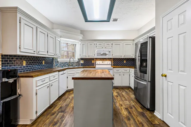 a kitchen with stainless steel appliances granite countertop a stove a sink and a refrigerator