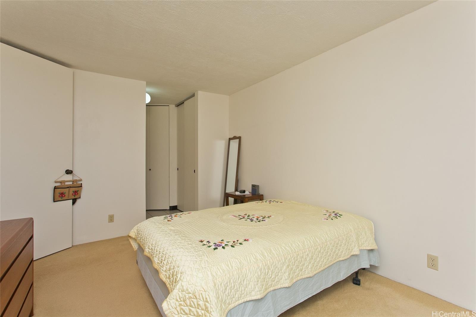 3138 Waialae Avenue, Unit 330 Honolulu, HI 96816 - Photo 9 of 17 a bed sitting in a bedroom next to a bathroom