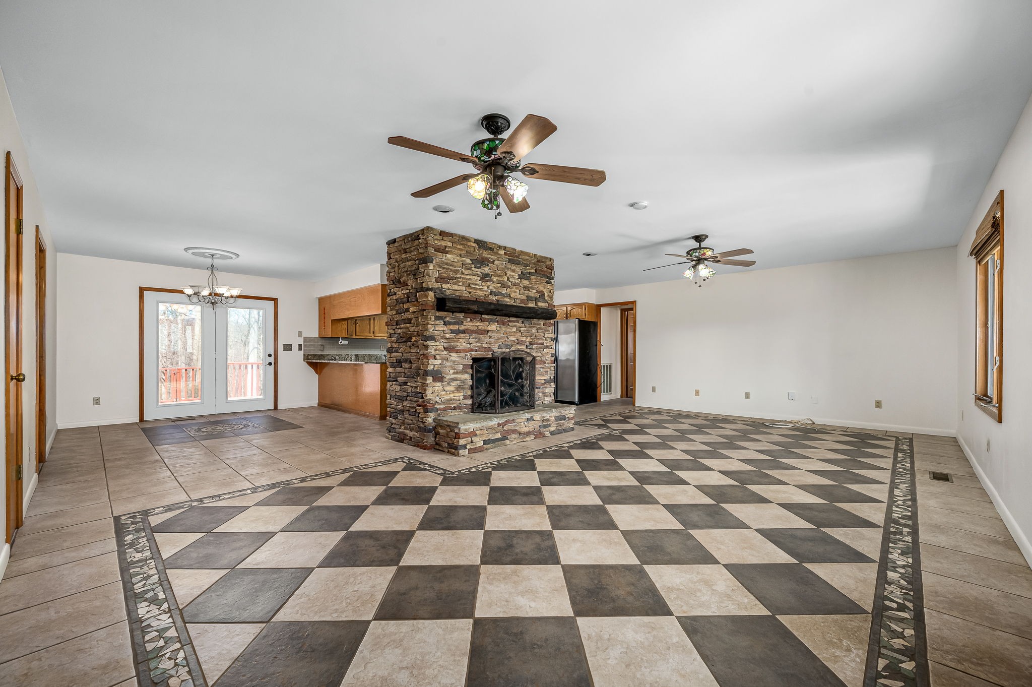 1246 Oakwood Road Joelton, TN 37080 - Photo 4 of 61 a living room with a black white checkered floor with a fireplace and a chandelier