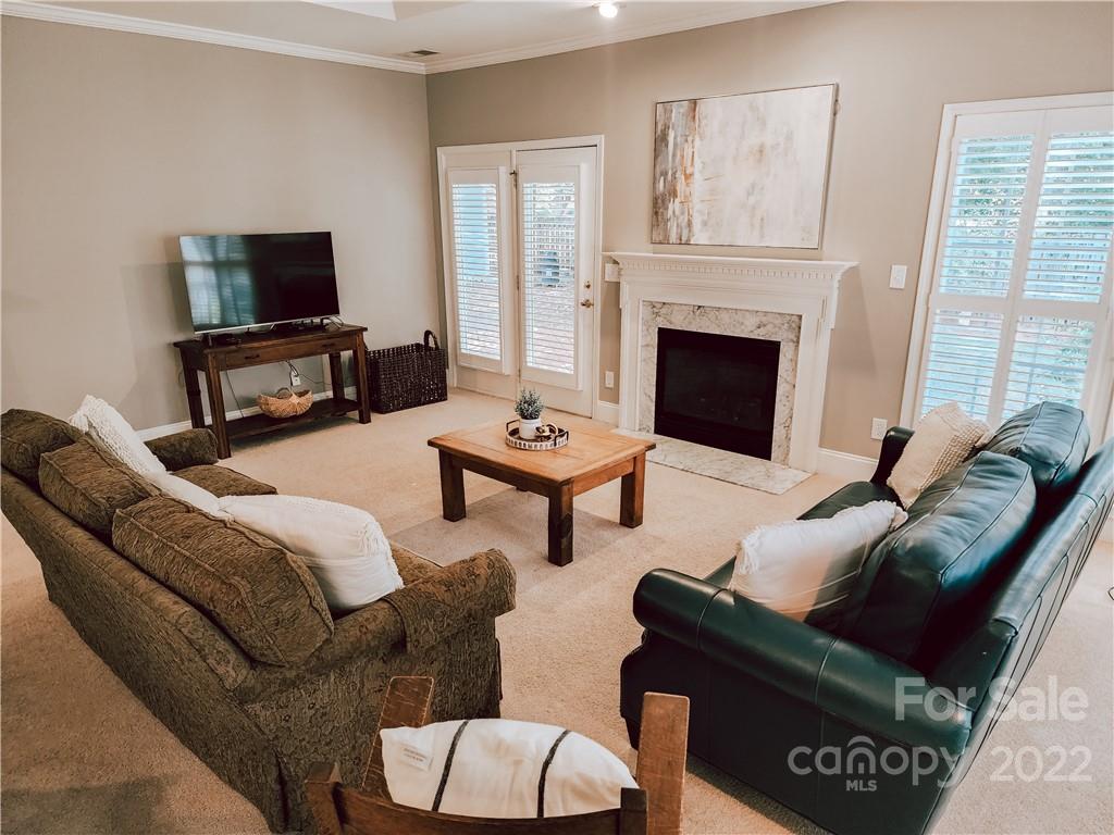 8408 Forest Shadow Circle Cornelius, NC 28031 - Photo 7 of 24 a living room with furniture a flat screen tv and a fireplace