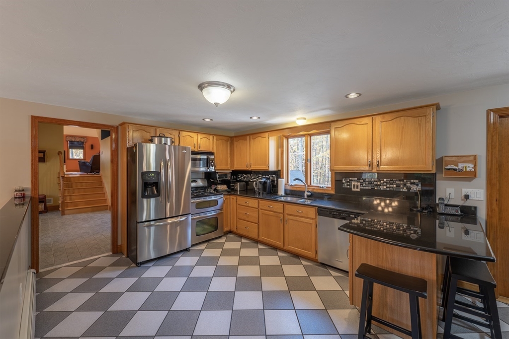 46 Long Pond Road Tyngsborough, MA 01879 - Photo 17 of 41 a kitchen with stainless steel appliances granite countertop a refrigerator and sink