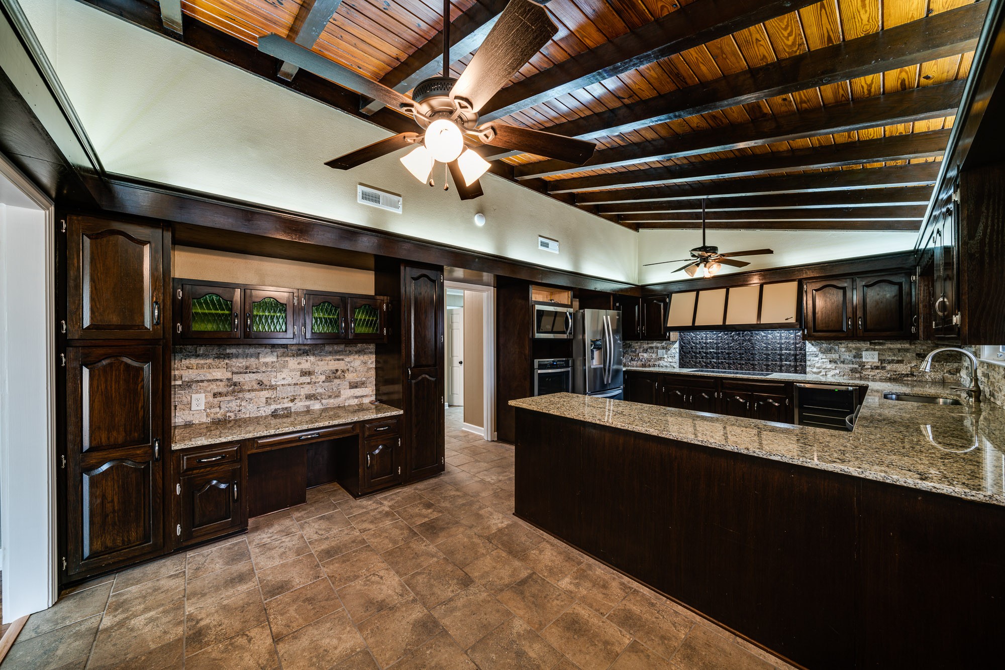 a large kitchen with stainless steel appliances granite countertop a stove and a refrigerator