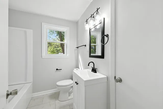 a bathroom with a toilet sink and mirror