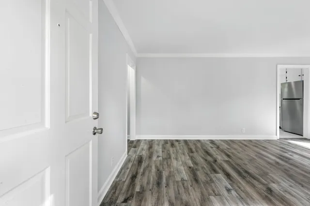 a view of a room with wooden floor and a ceiling fan