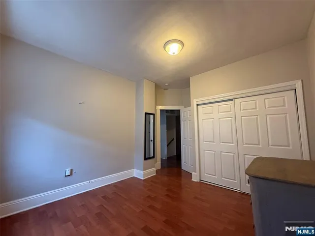 an empty room with wooden floor and closet