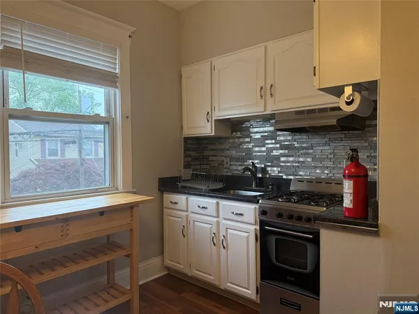 a kitchen with granite countertop a stove and a sink