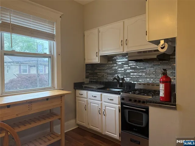 a kitchen with granite countertop a stove and a sink